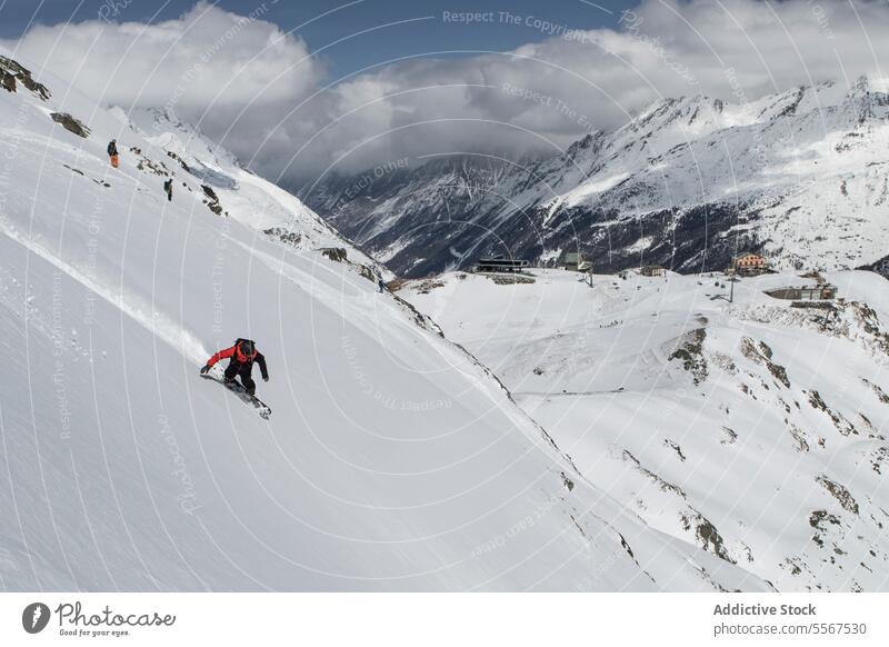 Snowboarder riding on slope of mountain during vacation unrecognizable snowboard person covering snowboarding warm suit cloudy sky swiss alps sport snowboarder