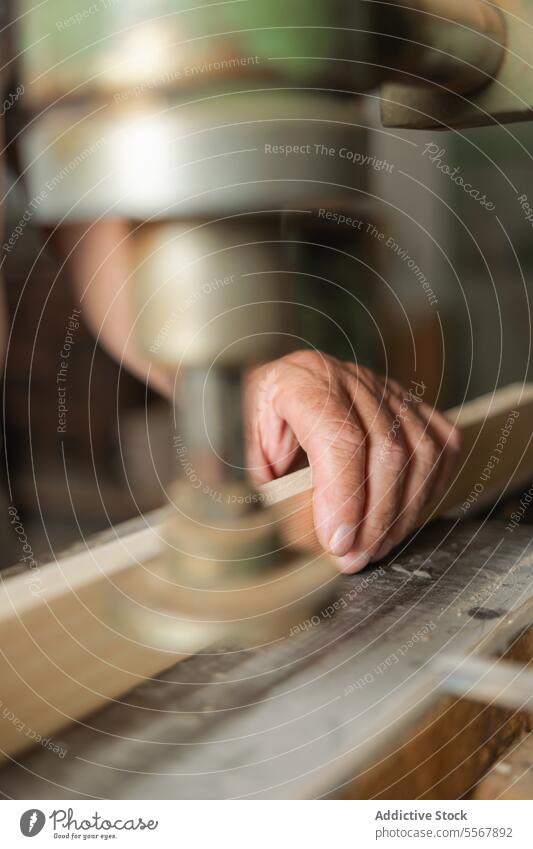 Detail of unrecognizable carpenter hand in Toledo workshop close-up carpentry wood machine tool detail guidance timber focus workbench craftsmanship manual