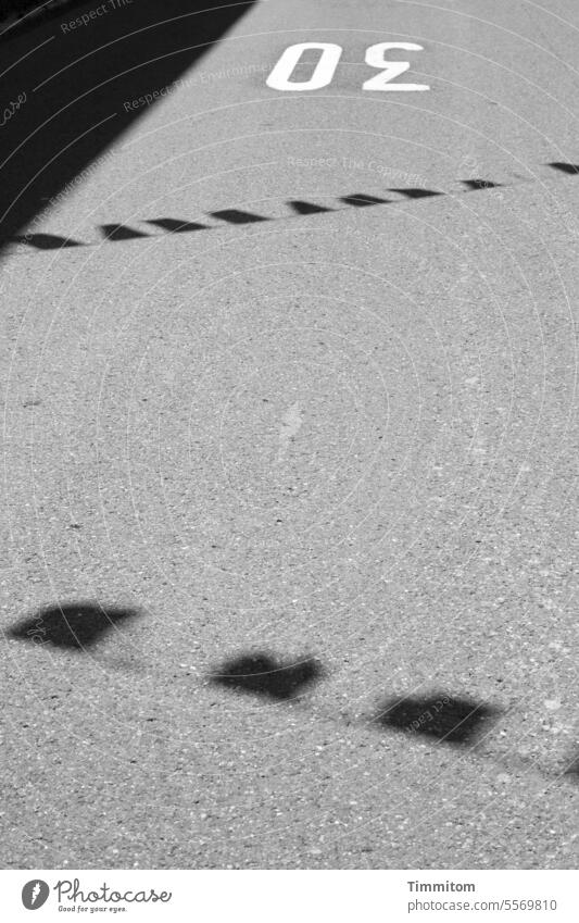 30 km/h road with the shadow of some pennants Street Asphalt Clue Boundary Speed Lane markings Signs and labeling Traffic infrastructure Shadow pennant chain