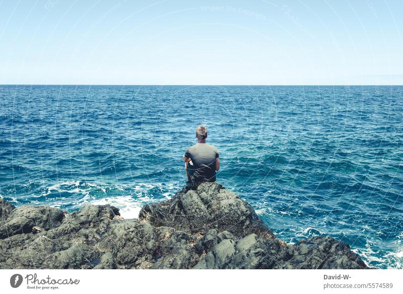 Man looks out to sea Ocean ocean tranquillity Far-off places Vacation destination vacation travel coast Water Tourism holidays Blue Relaxation Freedom sea noise