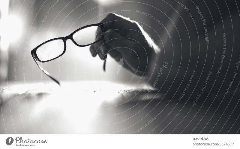 Man holding glasses in hand Eyeglasses Education Meditative thoughts education ponder blindness Hand Optics Optician Person wearing glasses Advertising concept
