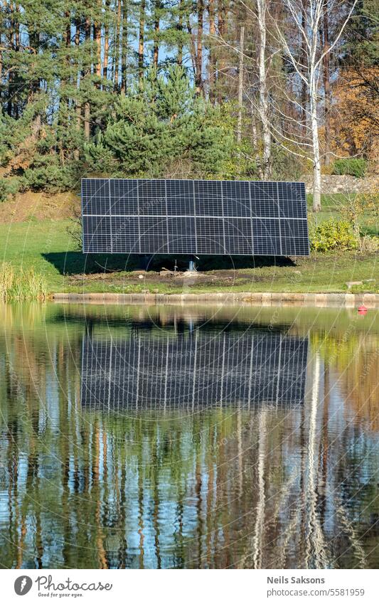 solar panels on river bank. Mirror makes them twice effective. energy electricity battery Energy Solar Power Electricity Renewable energy photovoltaics