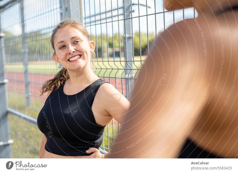 University student resting next to a fence on athletics track of her college.Spend time with friends women fitness sport healthy lifestyle female person