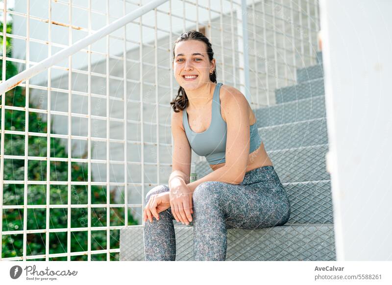 Portrait of a smiling and joyful young girl in sportswear sitting