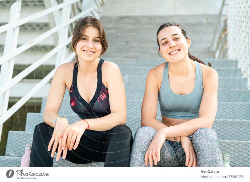 Portrait of two smiley female personal fit trainer looking at