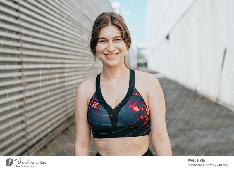 Smiling athletic girl doing series of exercises with a medicine ball on  training day. Urban scene. - a Royalty Free Stock Photo from Photocase