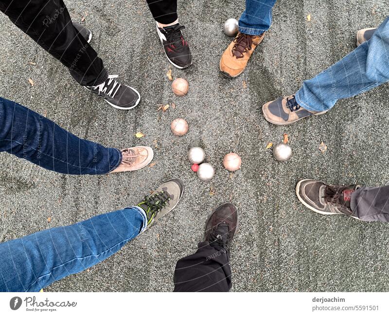 Discussion about which ball is closest to the red piggy petanque game Playing Exterior shot Sports play outdoors Movement Leisure and hobbies Colour photo