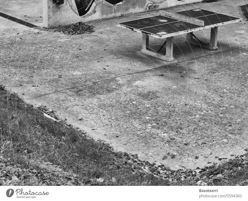 Concrete table tennis table on concrete court in front of concrete wall, black and white image Town City Table tennis Table tennis table ping-pong Deserted Gray