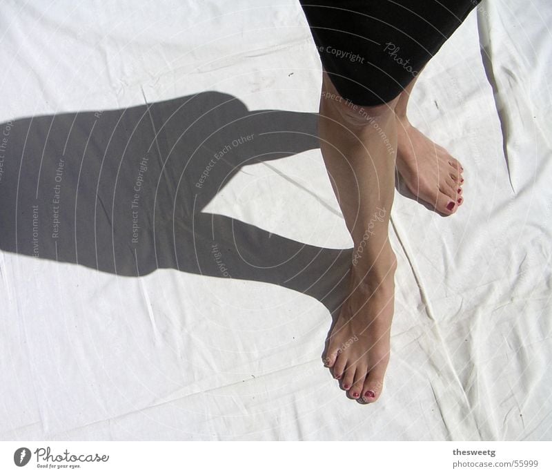 woman legs in black tight pants barefoot foot on shin Stock Photo