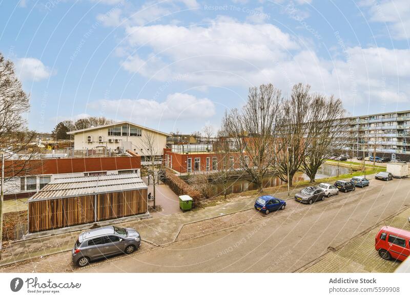 Buildings with cars parked on street in city building residential parking lot complex cloudy sky vehicle aerial view exterior apartment architecture house dwell