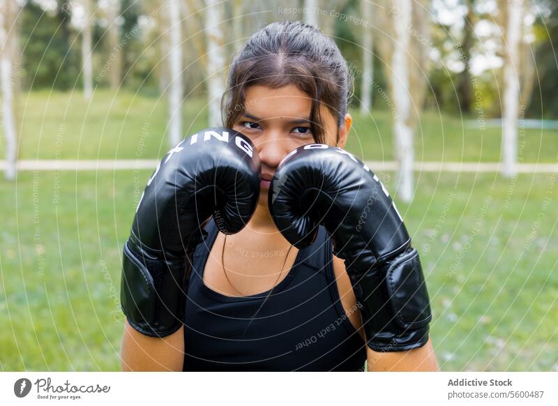 Boxer woman portrait wearing boxing gloves in a guard position active adult athlete black body boxer close up competition contact defense determination exercise