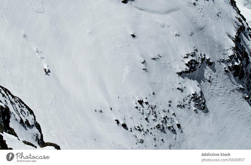 Top view of anonymous person skiing on snowy mountain at Swiss Alps on sunny day skier winter vacation enjoy swiss alps drone unrecognizable ride covering