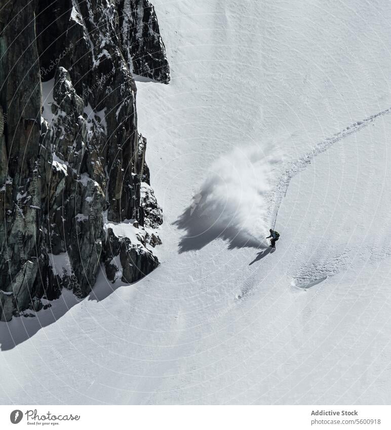 High angle of unrecognizable person skiing on snow mountain during vacation at Swiss Alps during sunny day skier enjoy winter covering swiss alps from above