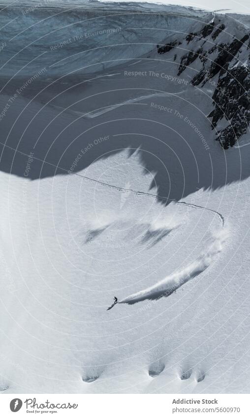 High angle of unrecognizable person skiing on snow mountain during vacation at Swiss Alps during sunny day skier enjoy winter covering swiss alps from above