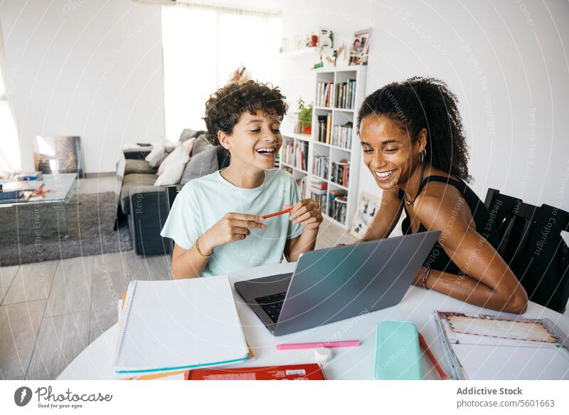 Girl doing her homework with mother Culture Family adorable affectionate after school bonding book cheerful child childhood children cute daughter day