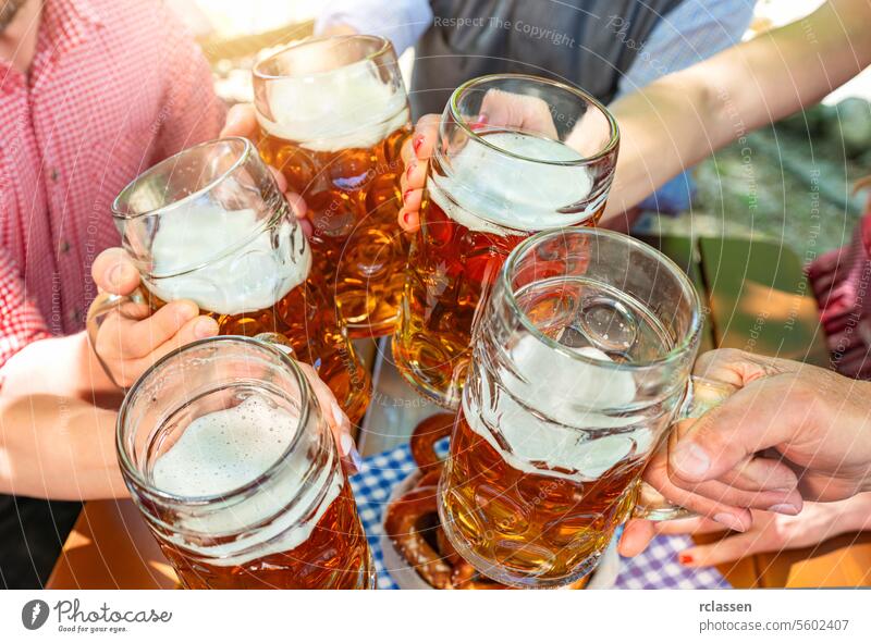 Five friends with a fresh beer in a Beer garden, close-up on beer stein oktoberst germany brezen bavaria bavarian bar celebration cheers dirndl lager hangout