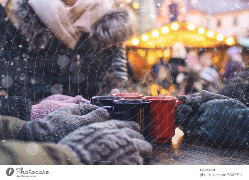 Hands in gloves around steaming mugs of mulled wine at a christmas market, with copyspace for your individual text. punch copy space advent german