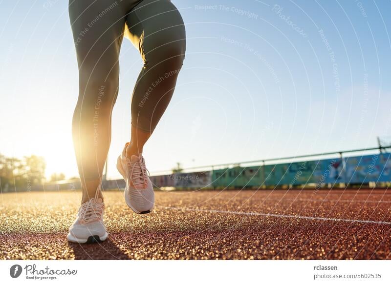 Close-up of runner's legs start to run on a track at sunrise running track jogging fitness exercise healthy lifestyle athletic wear sneakers workout morning run