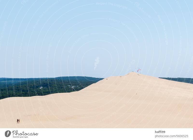 three people walking on a dune under cloudless sky - a Royalty Free Stock  Photo from Photocase