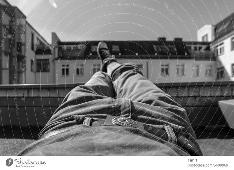 Man resting on the roof with his legs stretched out Chucks b/w Prenzlauer Berg Roof Legs chill Courtyard Berlin Sunlight Town Downtown Black & white photo