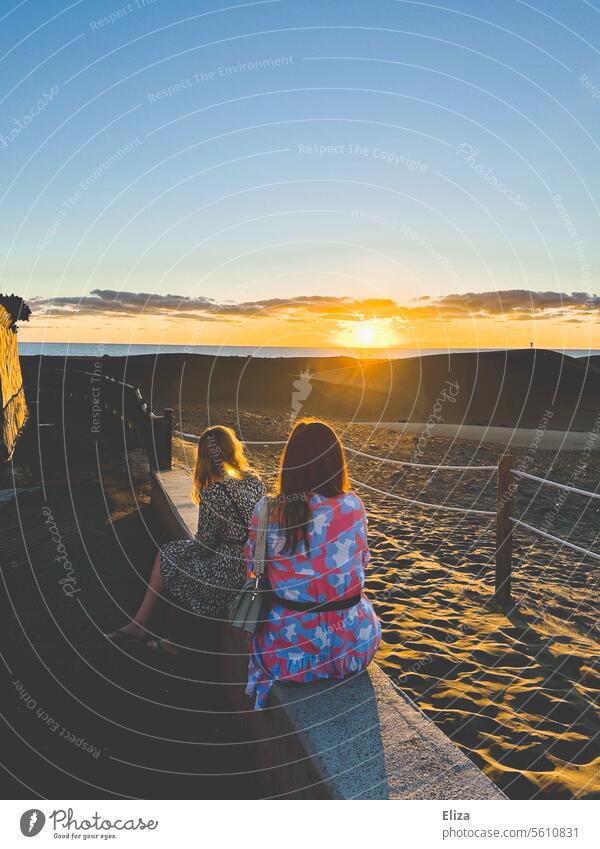 Two women watch the sunrise over the dunes of Maspalomas on Gran Canaria two Sunrise girlfriends Morning Summer dresses Sunlight Nature people vacation golden