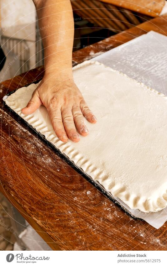 Chef's hand pressing dough edges in kitchen baker stuffed pastry raw crop unrecognizable making design shape cooking delicious bakehouse man fresh prepare