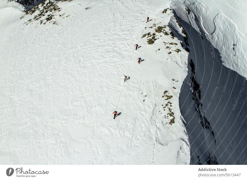 People snowboarding on snowy mountain people ride snowcapped aerial view unrecognizable group snowboarder enjoy vacation alps sunny winter highland altitude top