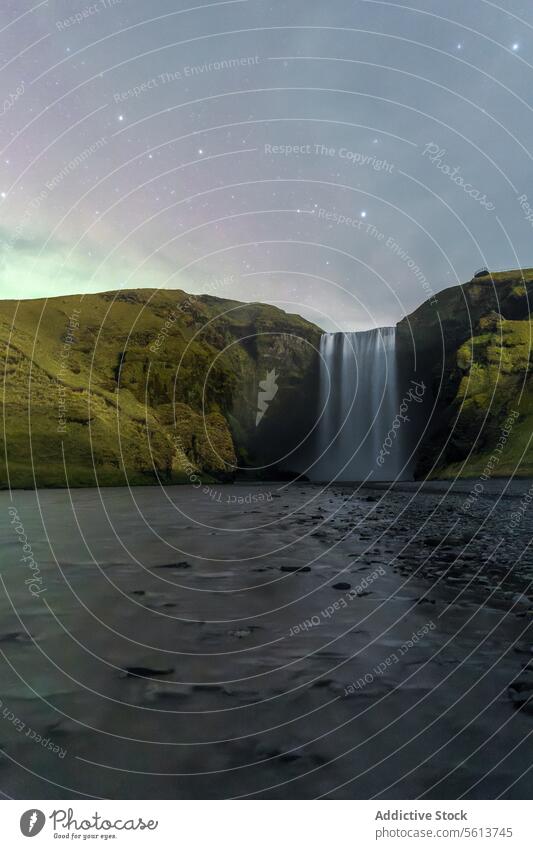 Majestic Skogafoss Waterfall under a Twilight Sky, Iceland waterfall twilight sky star nature landscape green cliff calm ethereal scenic beauty dusk outdoor