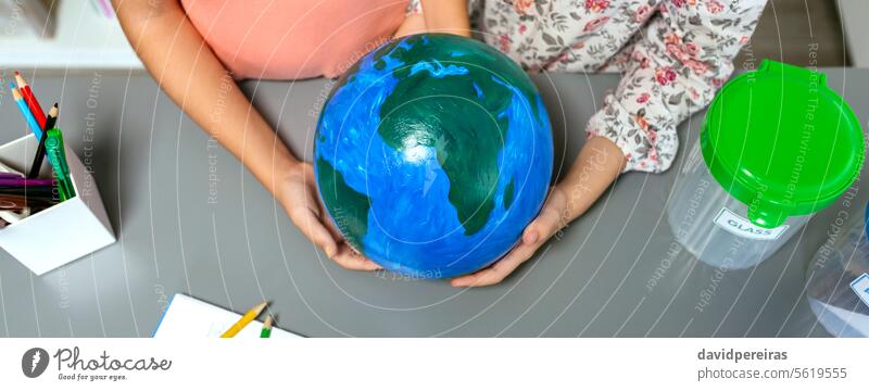 Two unrecognizable female students holding handmade globe world earth planet little girl school banner panorama web header panoramic education sustainable