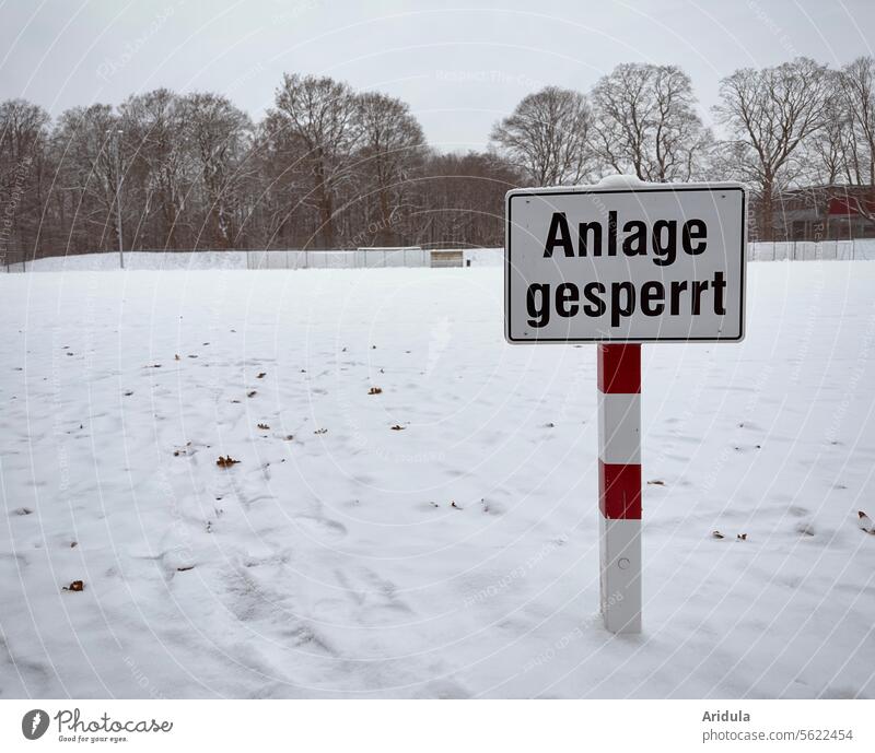"Facility closed" sign on snow-covered sports field System locked Winter Sporting grounds Snow Barred Signs and labeling Signage Deserted Warning label Safety