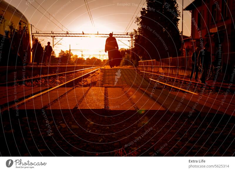 Passenger train is arrived to railway platform station, people walking in hurry, Sun in backlight Arrival Arrive Backlight Backlit Carriages Commute Commuter