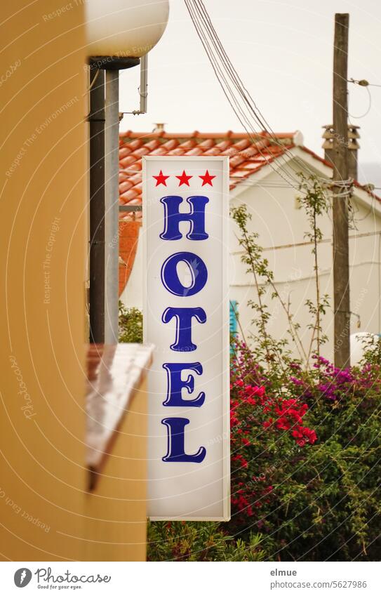 vertical sign with lettering *** HOTEL / flowers, electricity pylon and house in the background Hotel Accommodation travel Tourism 3-star hotel Elba Hostel
