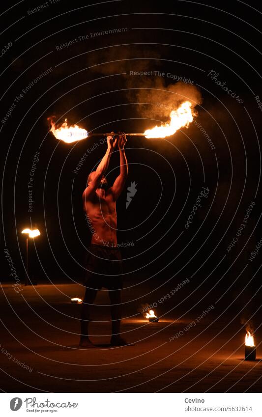 Fire-eater sips blaze Hot Dangerous peril Entertainment Torch warm Red orange Man Athletic muscle sexy Six pack erotic ardor Perspiration talent entertainment