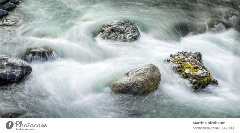 Fresh flowing water around boulders ina creek in the Yellowstone National Park, long exposure yellowstone river nature stream rock landscape travel waterfall