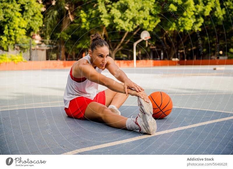 Woman stretching legs before playing basketball on court Sportswoman Basketball Player Warm Up Stretch Exercise Feet Sports Ground Training Determine Playground