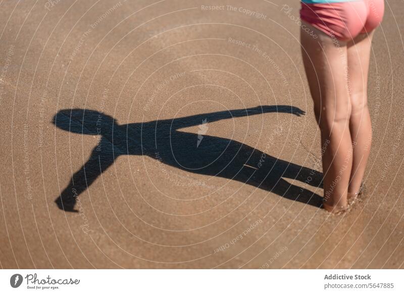 Shadow of a child on the beach kid sandy close-up shadow lower body anonymous summer adventure active lifestyle outdoors wetsuit hobby recreational activity