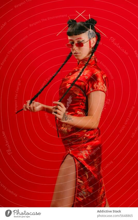 Stylish woman in red traditional Asian dress against red background asian dress cheongsam pose backdrop contemporary elegant culture outfit attire fabric