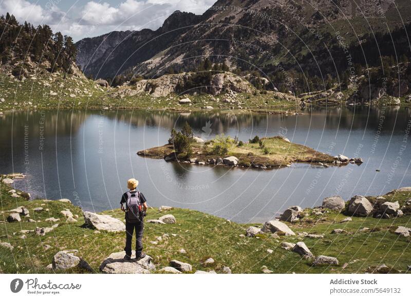 Man standing near calm lake in mountains during vacation Hiker Tourist Lake Mountain National Park Adventure Landscape Reflection Traveler Journey Tourism