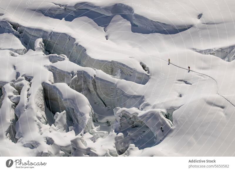 Aerial view of anonymous skiers in warm clothes Traversing a Snow-Covered Glacier in Zermatt, Switzerland glacier snow ice ridge trail alpine terrain