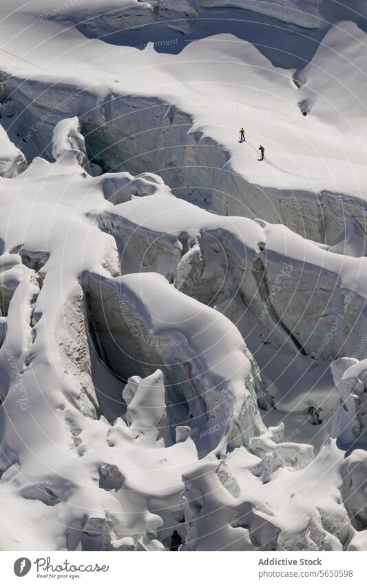 Aerial view of anonymous skiers in warm clothes Traversing a Snow-Covered Glacier in Zermatt, Switzerland glacier snow ice ridge trail alpine terrain