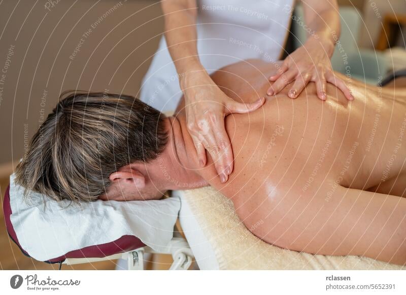 Close-up of a massage therapist working on a client's shoulder and back in a beauty salon shoulder massage back massage neck massage relaxation