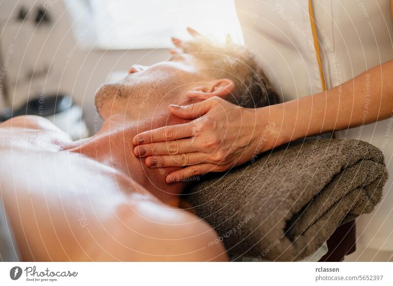Man receiving neck massage from therapist in spa Wellness Hotel physiotherapist hotel massage oils asian relaxation therapist's hands wellness stress relief