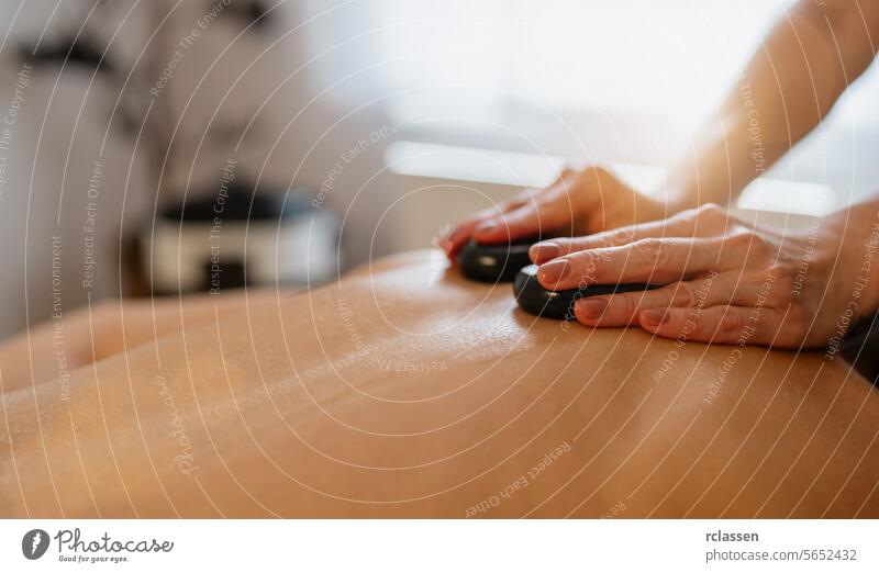 Close-up of a hot stone massage on a person’s back with therapist's hands. beauty salon Wellness Hotel Concept image asian hotel pressure point back massage