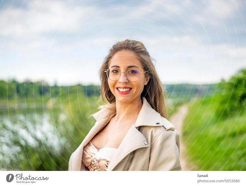happy young woman with glasses stands in a meadow Woman fortunate youthful Laughter pretty Single cheerful portrait Attractive optimistic relaxed Joy