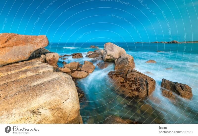 Rocky coast, lapped by the sea, under a blue sky Maritime Ocean Vacation & Travel Landscape Summer Waves Sky Water Wanderlust tranquillity relaxation Brown