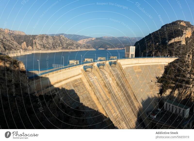 A vast dam with significantly reduced water levels in a mountainous area showcasing the potential effects of drought reservoir low level environment climate