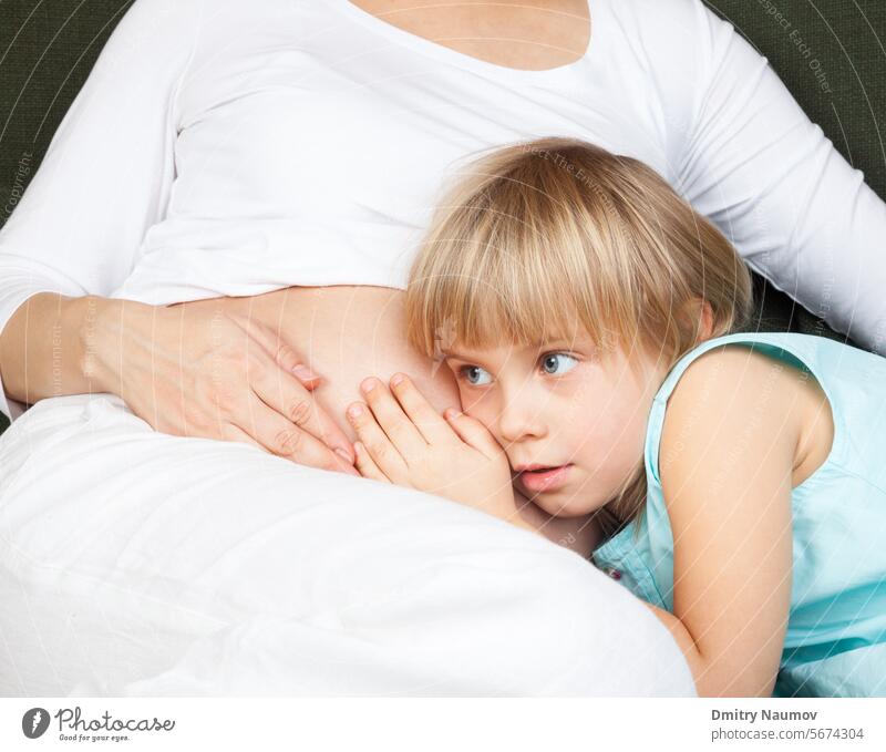 Pregnant woman with daughter affectionate anticipation anxiously awaits babies belly brother care caucasian child childhood embryo expectation expecting family
