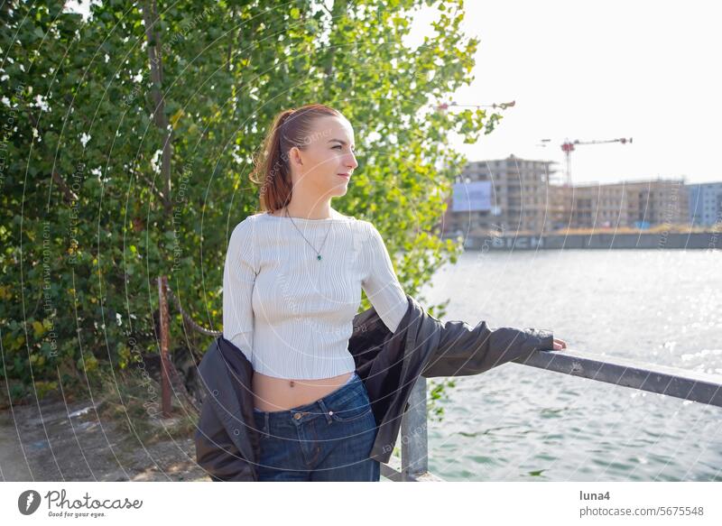 young woman with leather jacket enjoys the fall sun at the river Spree Woman Girl sunbathe teenager Sun To enjoy bank Autumn fortunate Joy untroubled