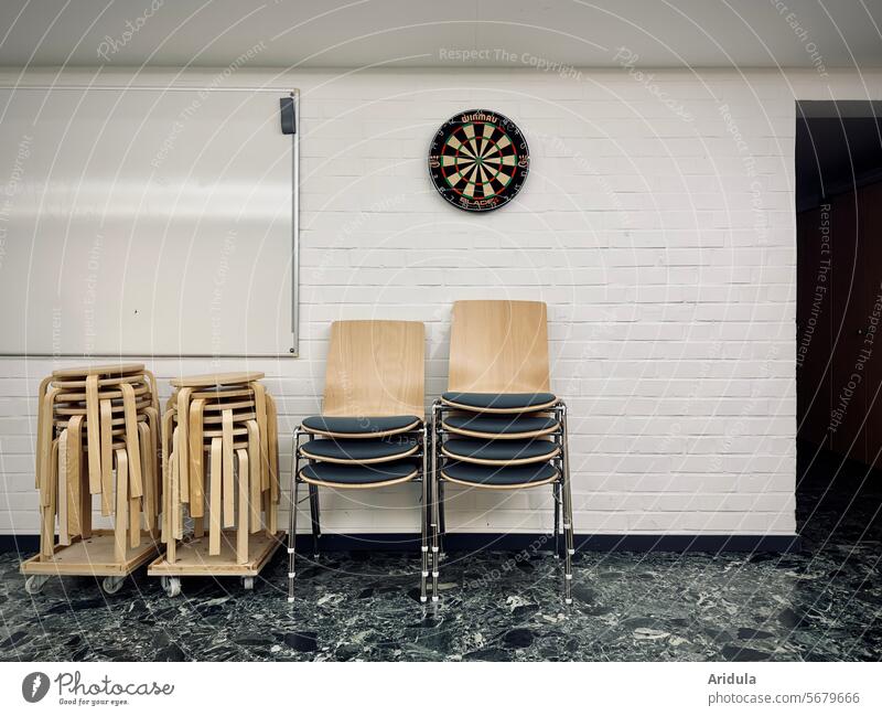 Chairs and stools in front of a white wall with whiteboard and dartboard Dartboard Wall (building) chairs Stool Stack Seating Seminar Seminar room Deserted