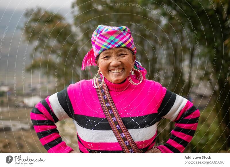 Elderly woman in warm clothes standing on hill cheerful sweater smile slope elderly senior nature happy tree positive female sun rural weekend glad bright style